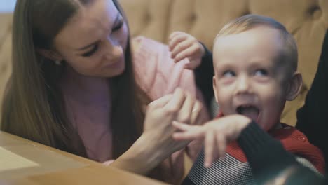 little boy in coloured pullover hugs mother and father