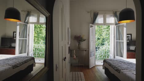 a bedroom with open doors leading to a balcony