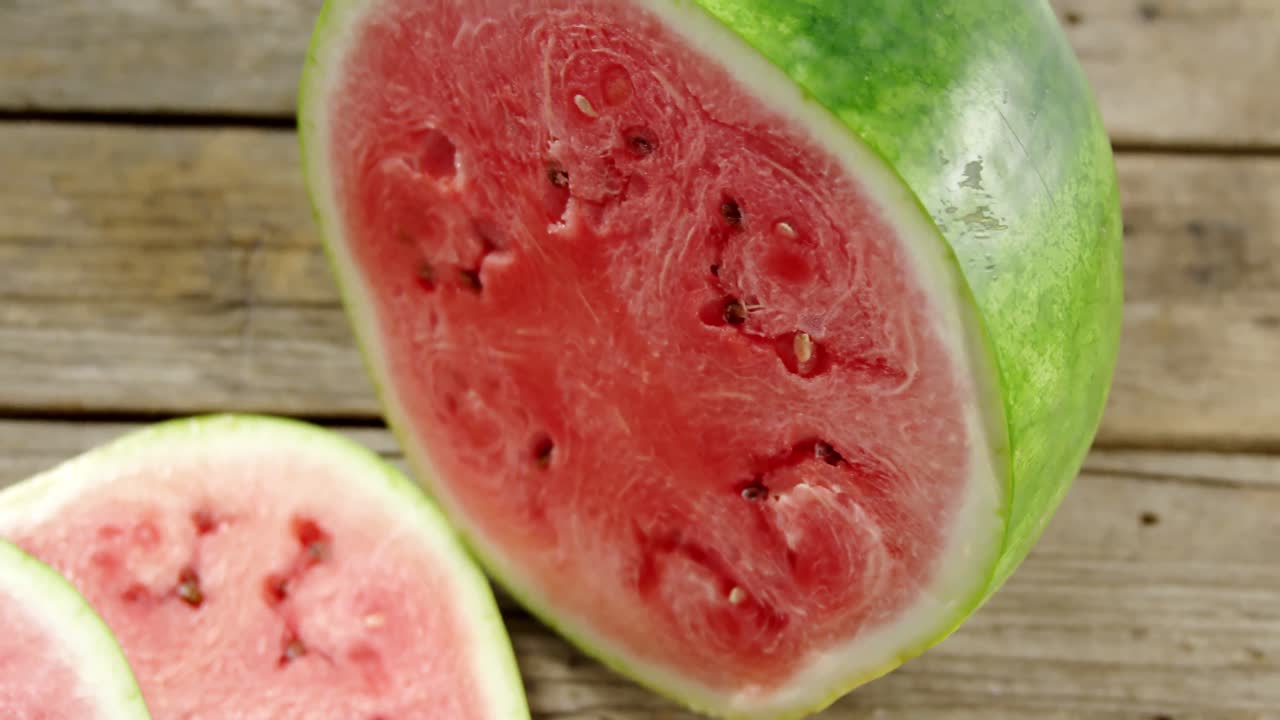 나무 테이블 에 있는 수박 의 조각 과 절반