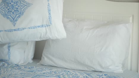 closeup of a white bed with blue patterned bedding