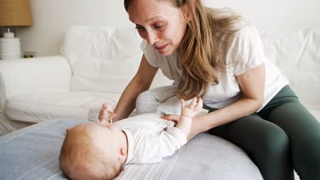 Cheerful-mom-playing-with-baby-daughter