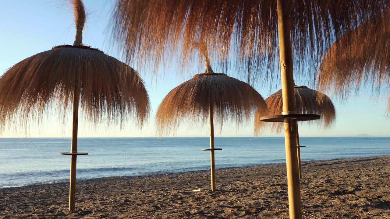 toma de cardán de sombrillas en la playa de marbella al amanecer, imágenes dinámicas de vacaciones