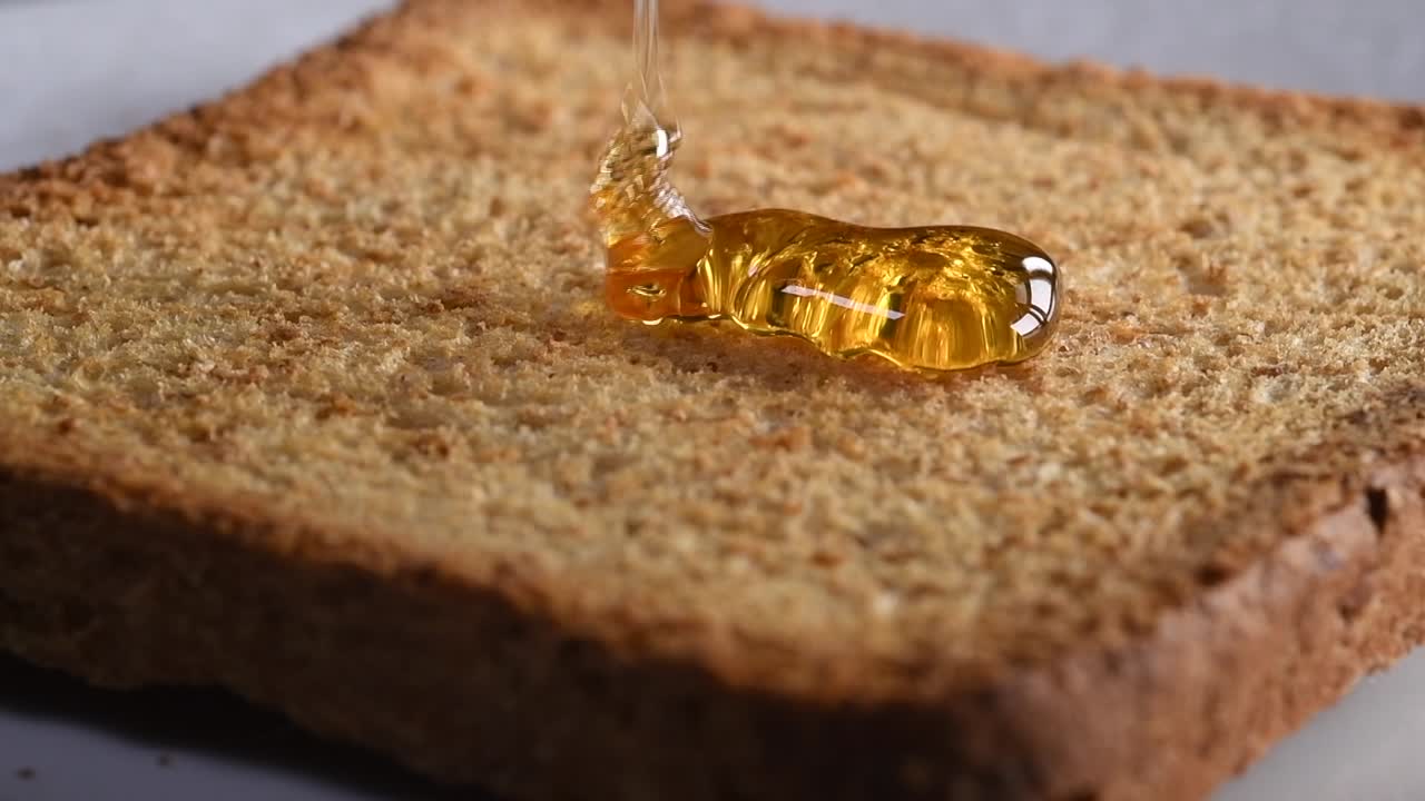 Miele che cade su toast al rallentatore.
