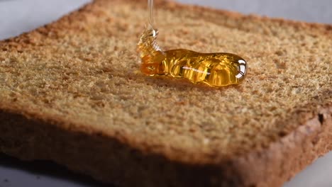 honey falling on toast in slow motion