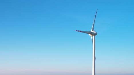 one wind turbine against clear blue sky - clean energy concept