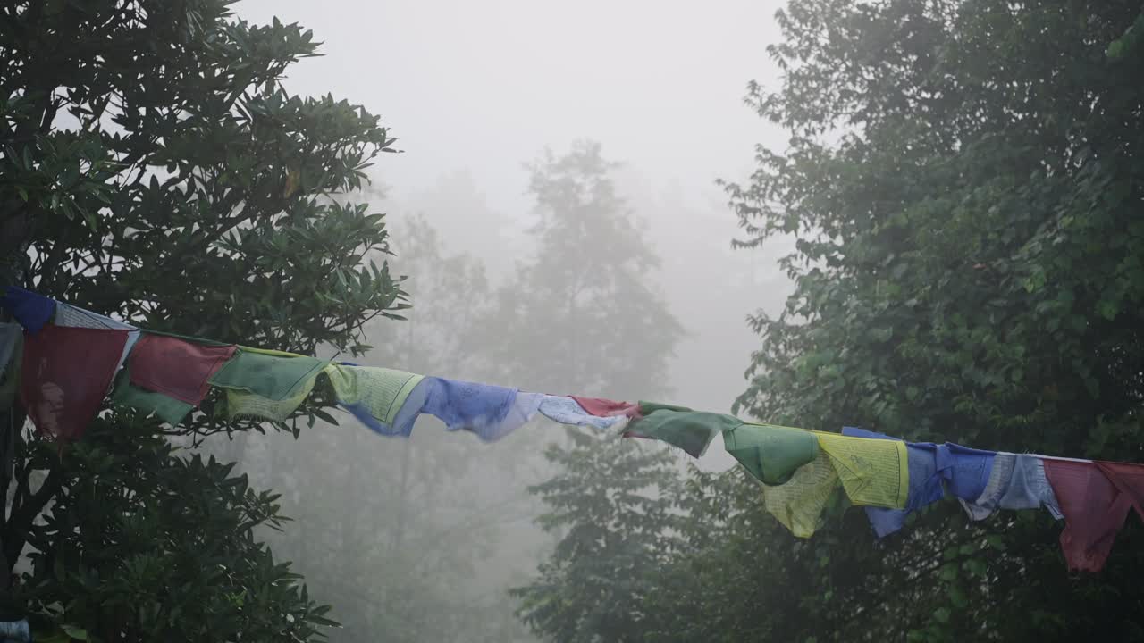 Misty Blue Buddhist Prayer Flags in Nepal, Religious Prayer Flags in Mist and Nature in Forest Scenery Landscape in Foggy Moody Blue Atmospheric Mood Scene in the Himalayas in Tranquil Peaceful Scene
