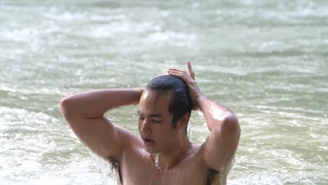 asian man in tropical natural pool, slow motion