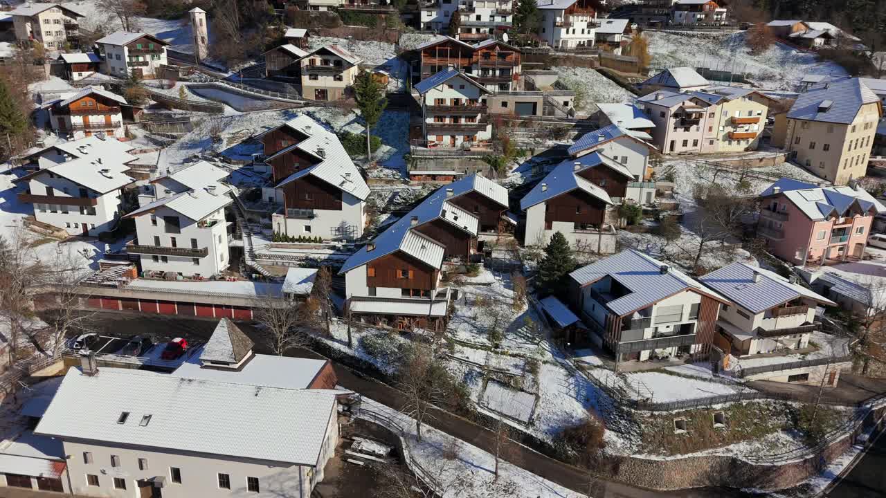 Low altitude aerial footage of Tiers Tires in South Tyrol Alto Adige Italy showing rooftops buildings narrow streets and snow covered ground in a traditional alpine mountain village