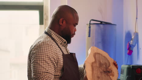 Portrait-of-jolly-man-inspecting-wood-piece,-evaluating-lumber-block