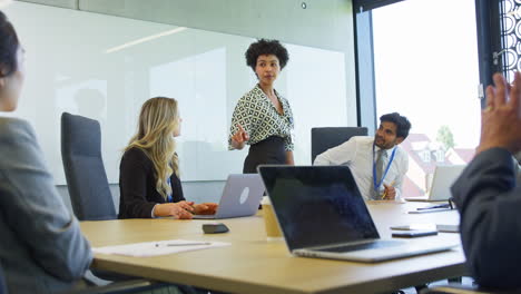 Businesswoman-Leading-Multi-Cultural-Business-Team-Meeting-And-Collaborating-Around-Table-In-Office