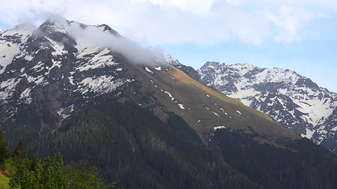 Luce solare che si muove attraverso le cime montuose innevate.