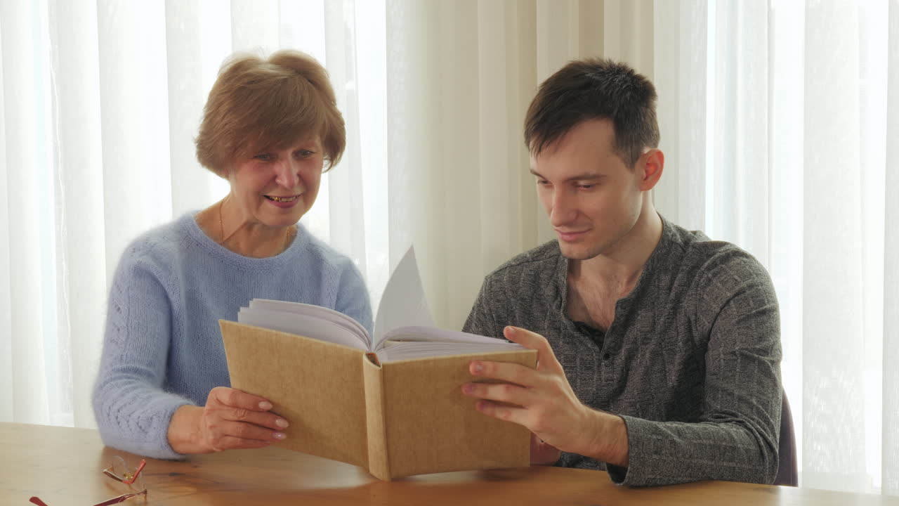 abuelo y nieto mirando un álbum de fotos