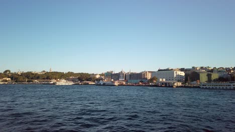 Evening,-cinematic-slow-mo,-a-captivating-view-of-Eminonu-from-a-ferry-on-the-Golden-Horn-in-Istanbul