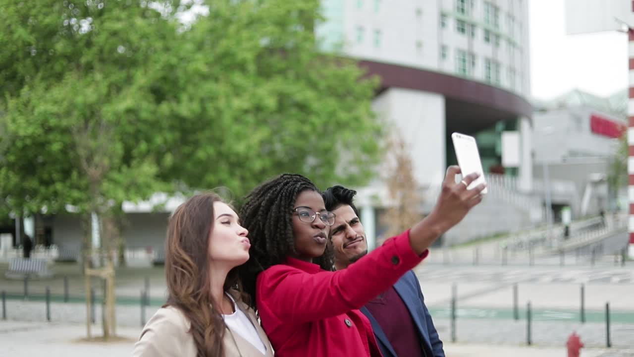 mujeres y hombres haciendo selfies afuera, posando, sonriendo