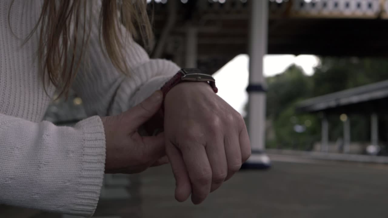 Woman with wrist watch in train station medium shot