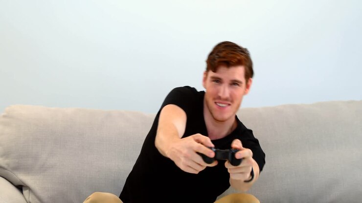 Man playing joystick game on sofa 4k