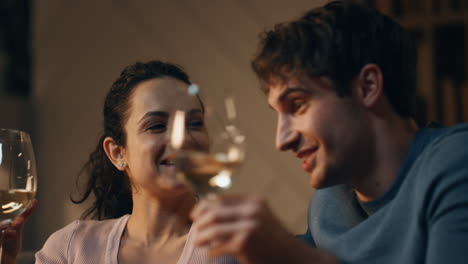 happy spouses clinking glasses with wine sitting home late night close up.