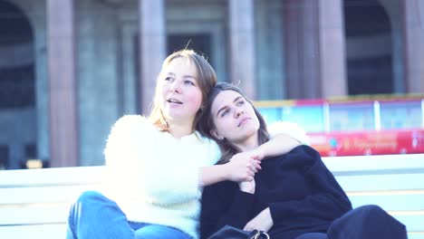 zwei frauen sitzen auf einer bank