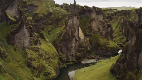 volando a través de escarpados acantilados escarpados en el cañón fjadrargljufur en el sur de islandia