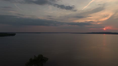 Late-day-aerial-shot-of-body-of-water-and-pink-sunset-in-Canada