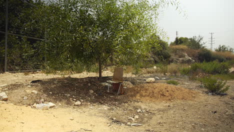 Wide-Shot,-A-Single-Chair-Sits-Alone-in-the-Desert,-Shed-in-Background