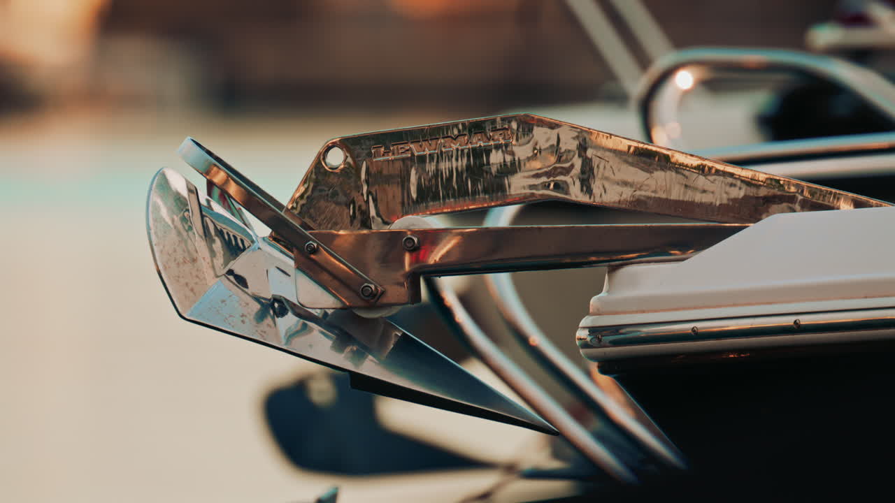 Cannes, France - November 7, 2025: Close up of a polished stainless-steel boat anchor mounted on the bow roller at a marina