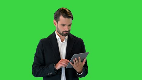 joven empresario trabajando con una tableta digital en una pantalla verde, clave de croma