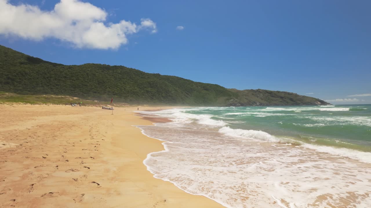 Caminhada em câmera lenta em uma praia de areia comprida e vazia, Lagoinha do Leste, em Florianópolis, Brasil