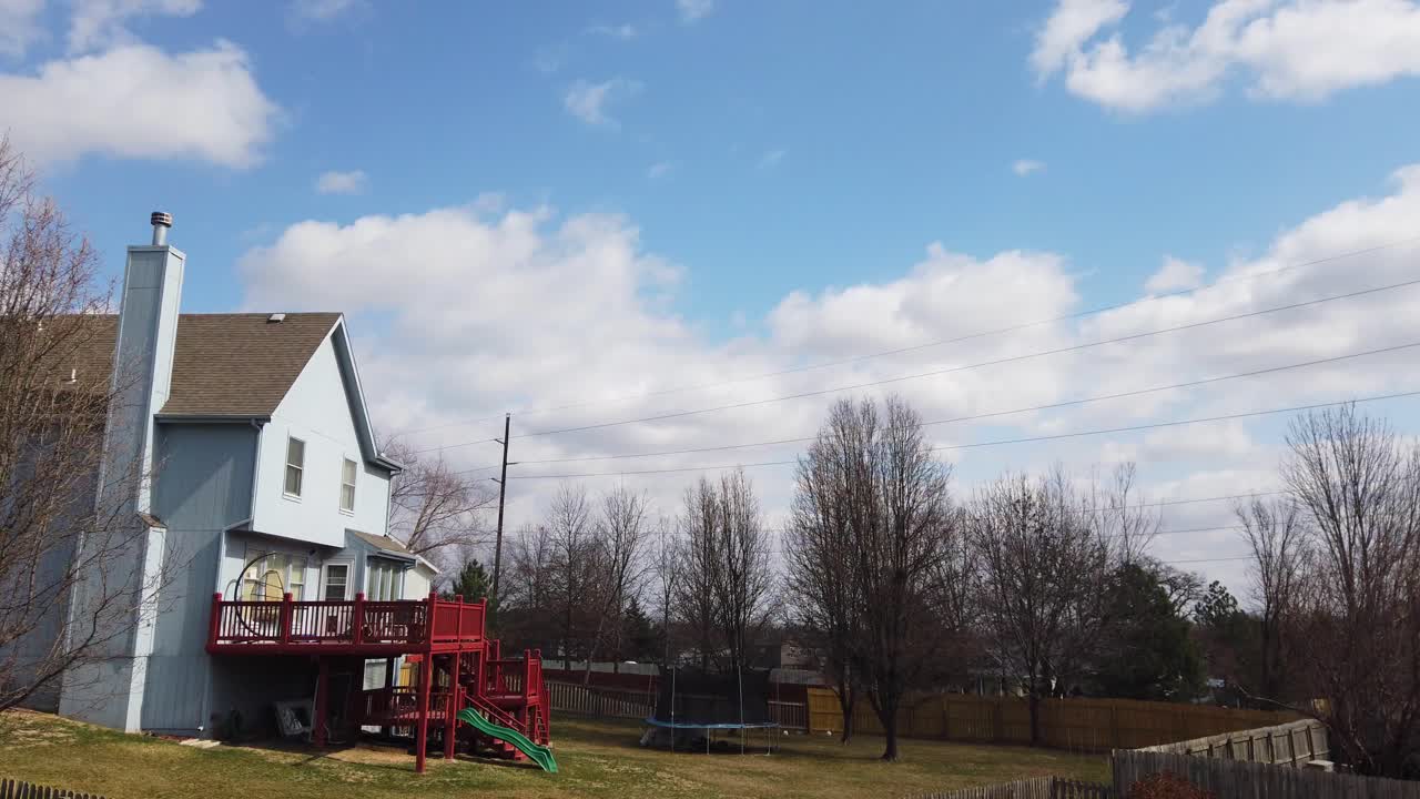Pan across beautiful blue sky with clouds and very windy trees