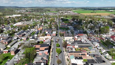 Aerial-backwards-shot-of-american-town-with-historic-buildings-and-driving-cars