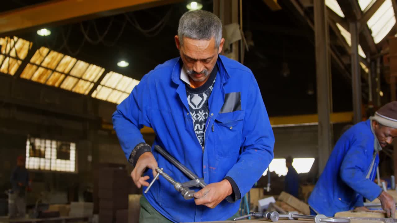 trabajador ajustando la pinza en el taller de fundición 4k