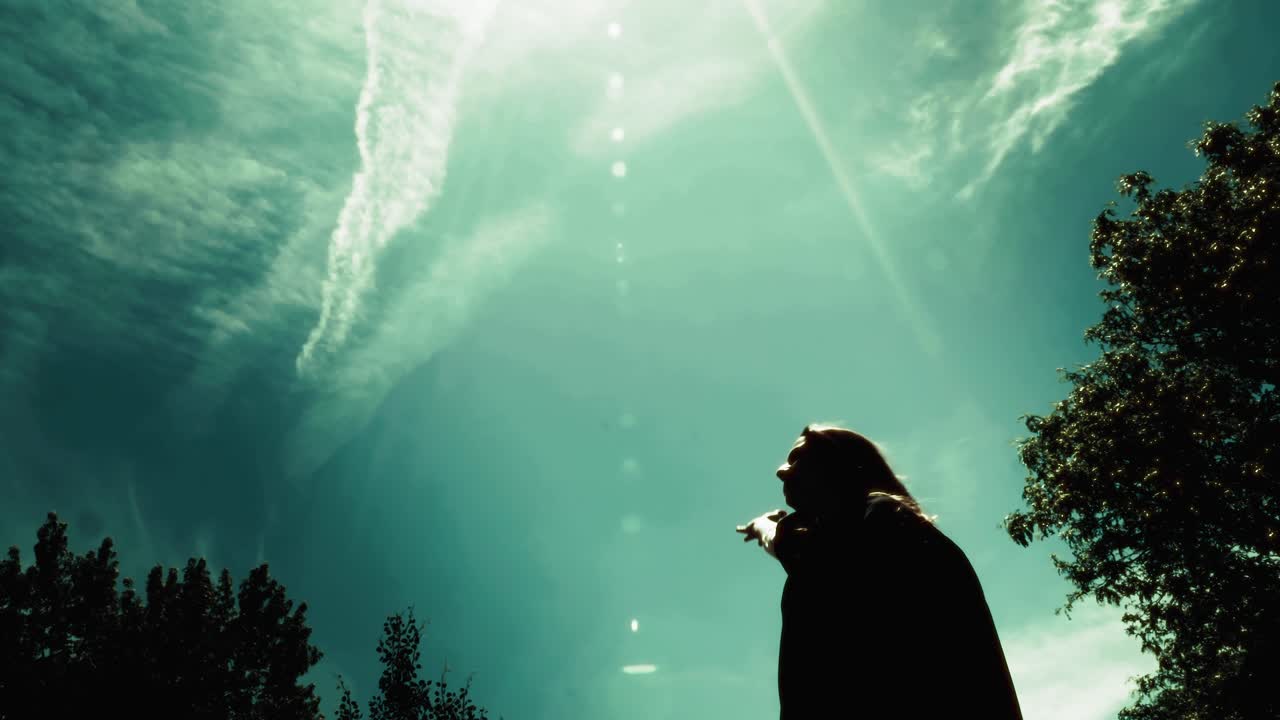 Silhouette of female graduate student throwing cap into the air. Shot in glorious slow motion.