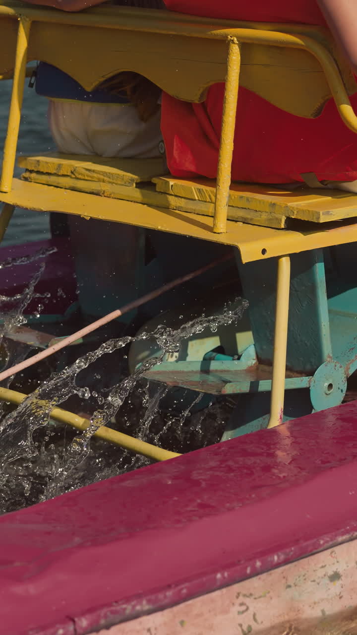 las cuchillas del catamarán rocian agua de mar clara. madre e hija turistas mueven los pedales del transporte acuático deslizándose en movimiento. estilo de vida activo y recreación