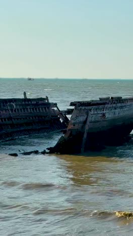 a broken boat rests on pattaya beach