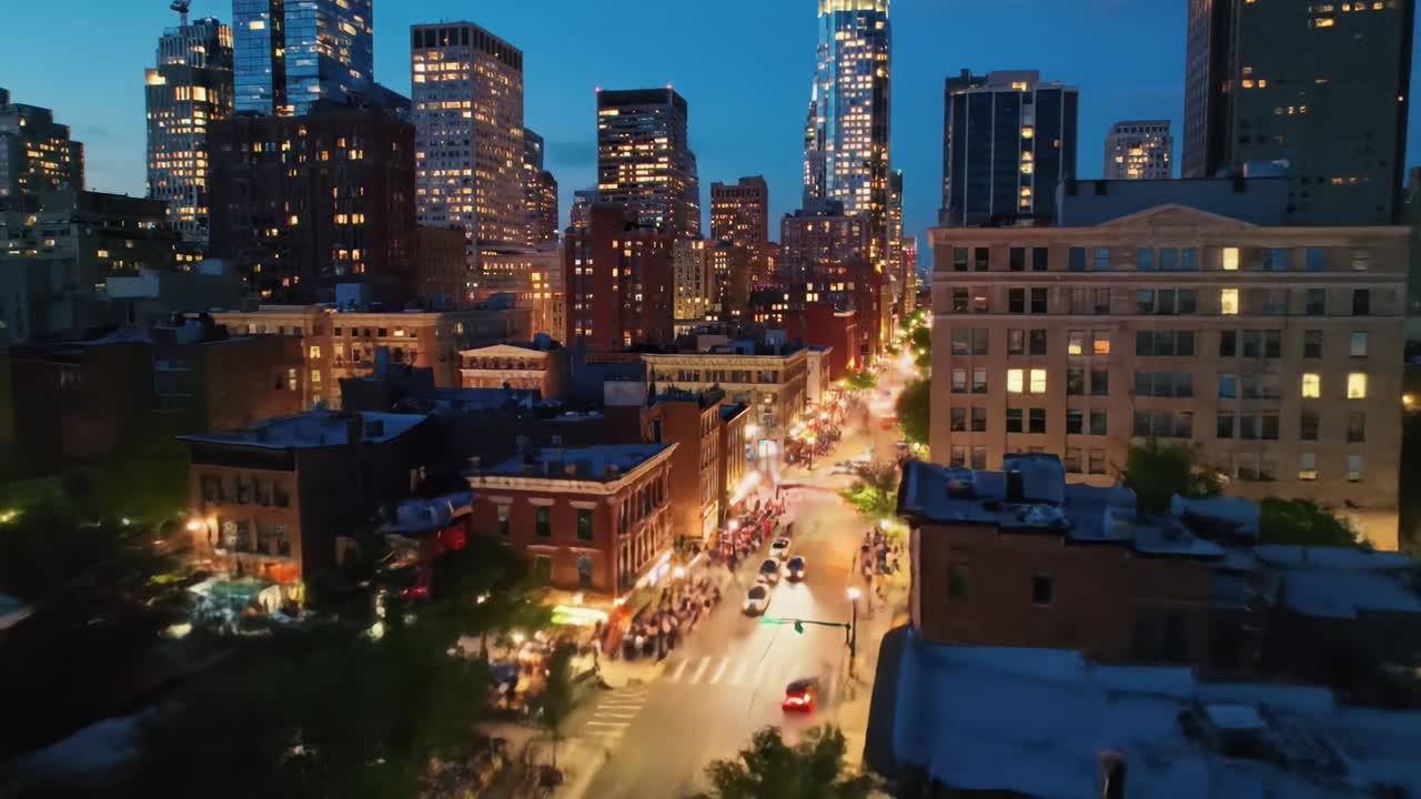 As dusk settles over the city, skyscrapers shine against the twilight sky. Streets bustle with evening traffic while bright lights create a lively atmosphere.