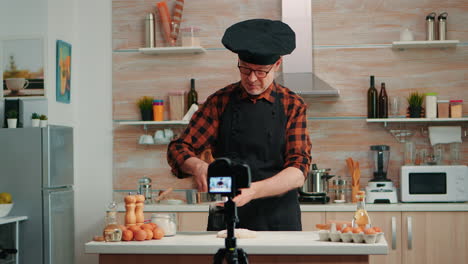 hombre anciano filmando un vlog de cocina