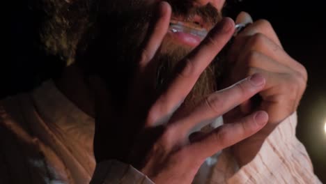 hombre tocando la armónica por la noche