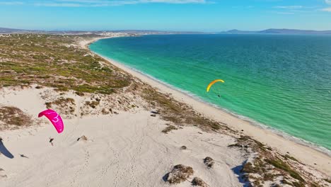 parapentes en acción sobre el agua en la laguna de langebaan, sudáfrica