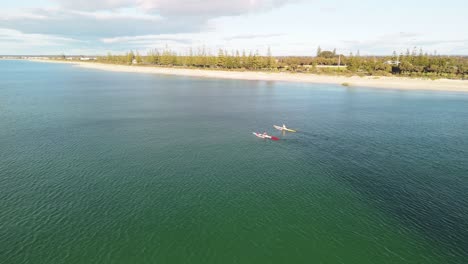 kayaking on a calm ocean near a sandy beach