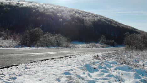 一辆汽车经过并消失在雪<unk>的冬天干燥的路上