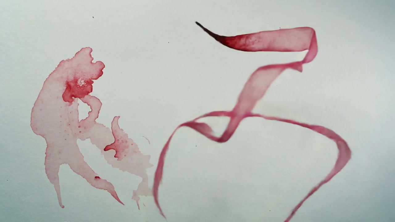Nastro rosso sottile che si srotola scorrendo su un foglio bianco, spinto con uno strumento per formare anelli sul pigmento