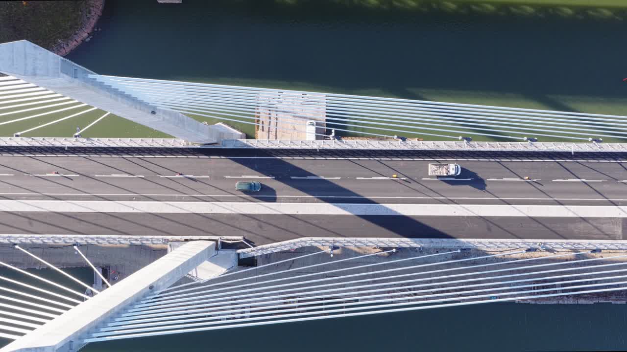 Aerial top down view from above cable-stayed bridge pylons. 83 meters high concrete pylon pairs support bridge over waterway