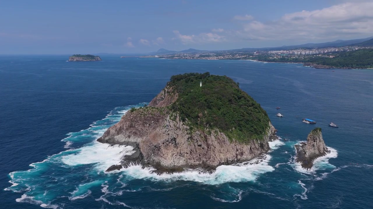 L'isola di Munseom al largo di Seogwipo, sull'isola di Jeju, in Corea del Sud, presenta una costa rocciosa vulcanica circondata da acque oceaniche limpide e un ricco scenario marino vicino al porto di Seogwipo - ripresa con drone.