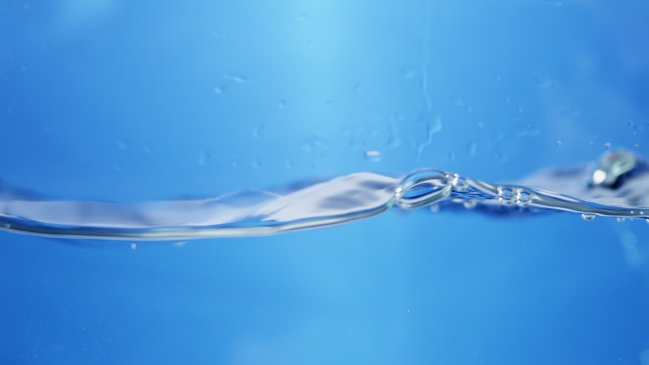 Waves of sparkling water, create some bubbles and droplets in a container.