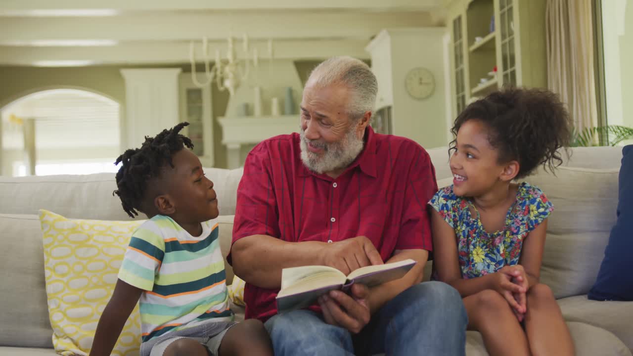 Grandfather and grandchildren reading book at home