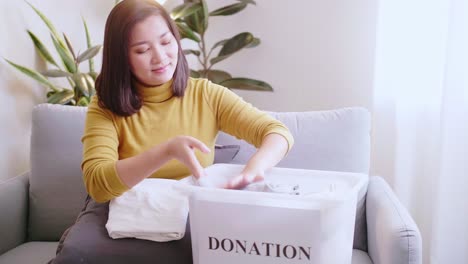 woman pressing phone using a credit card to pay online to reserve donation box delivery