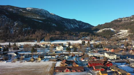 acercándose a la iglesia de nesbyen en hallingdal, noruega, durante la hermosa luz del sol matutino - hora dorada aérea con paisajes de invierno en los alrededores