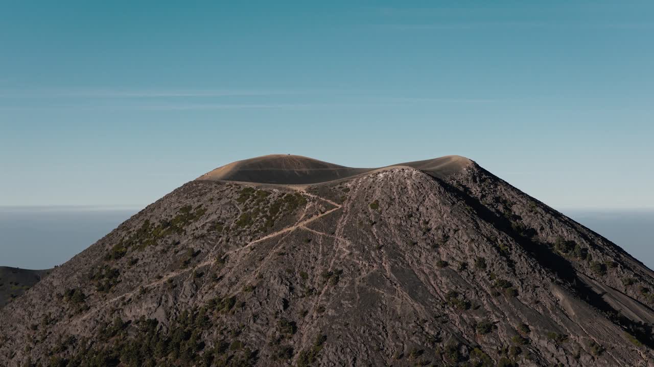 Veduta aerea della vetta del Vulcano Acatenango e della cresta del cratere in Guatemala sotto un cielo diurno limpido.