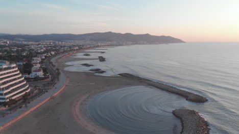 un dron captura la ciudad costera mientras las tranquilas olas del océano se lavan contra numerosos muelles de piedra que se extienden hacia el agua temprano en la mañana