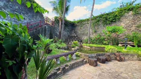 Peaceful garden courtyard with pond, palm trees, and log stools—ideal for resort, eco-tourism, or wellness retreat visuals